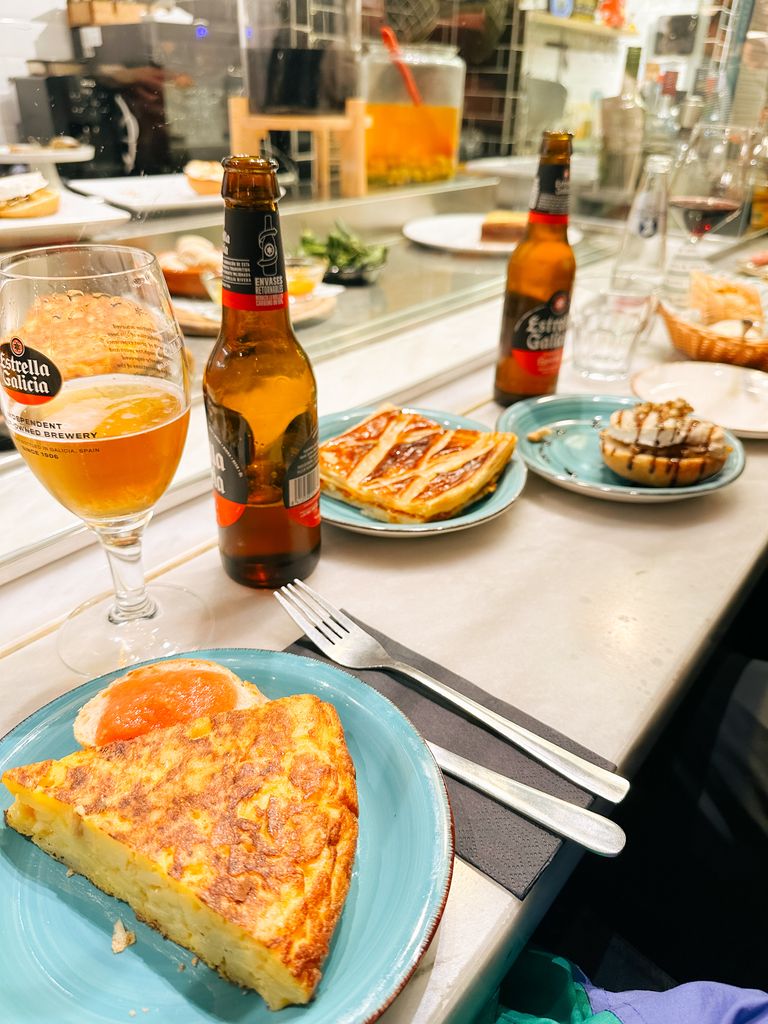 Close-up of traditional Spanish tapas with beer in a Berlin restaurant setting.